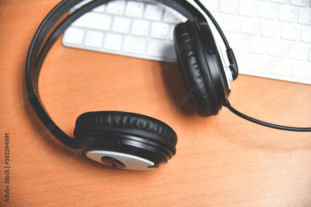 Black headset on table of technical support agent in office Black headset on table of technical support agent in office