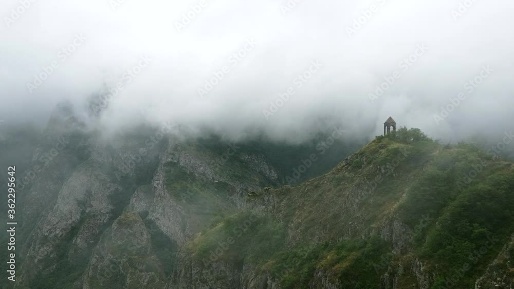 Aerial Drone view of Small chapel in the top of the mountain, surrounded by fog and clouds. Highland old building in Armenia, Caucasus Aerial Drone view of Small chapel in the top of the mountain, surrounded by fog and clouds. Highland old building in Armenia, Caucasus