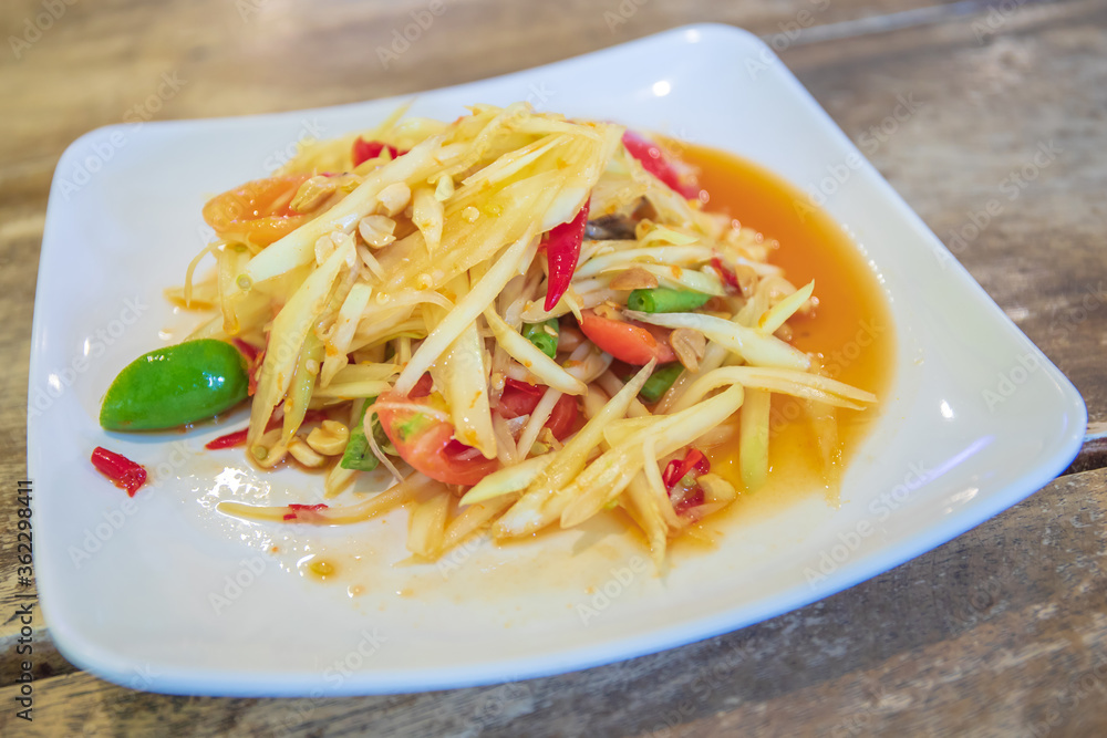 Closeup to Famous Thai food, papaya salad or SOM TAM or Somtum. in white plate.