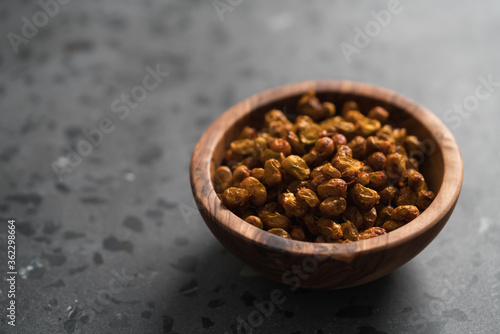 dried seaberry buckthorn in olive bowl on terrazzo countertop with copy space