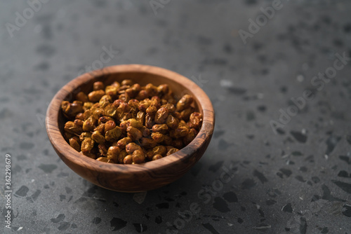 dried seaberry buckthorn in olive bowl on terrazzo countertop with copy space