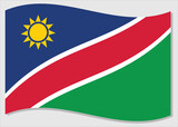 Waving flag of Namibia vector graphic. Waving Namibian flag illustration. Namibia country flag wavin in the wind is a symbol of freedom and independence.