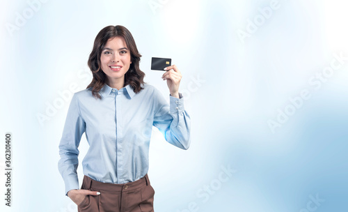 Smiling businesswoman holding credit card, mock up