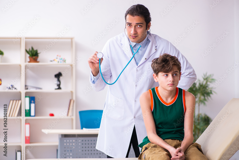 Sick boy visiting young male doctor pediatrician