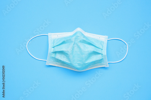 Surgical face mask on blue background protection against COVID-19 coronavirus. Healthcare and medical concept