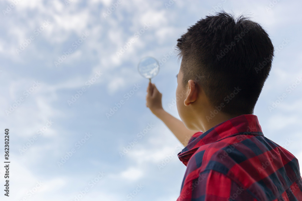 Young boy holding magnifying glass looking sky, Interest planet concepts. Young boy holding magnifying glass looking sky, Interest planet concepts.