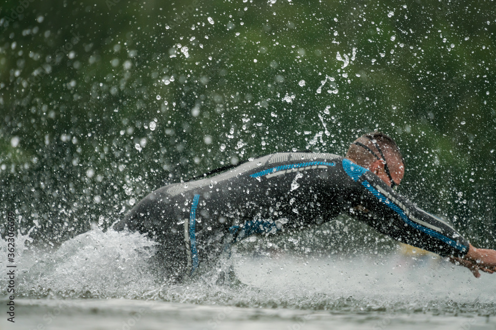 Triathlete in a wetsuit running into the lake