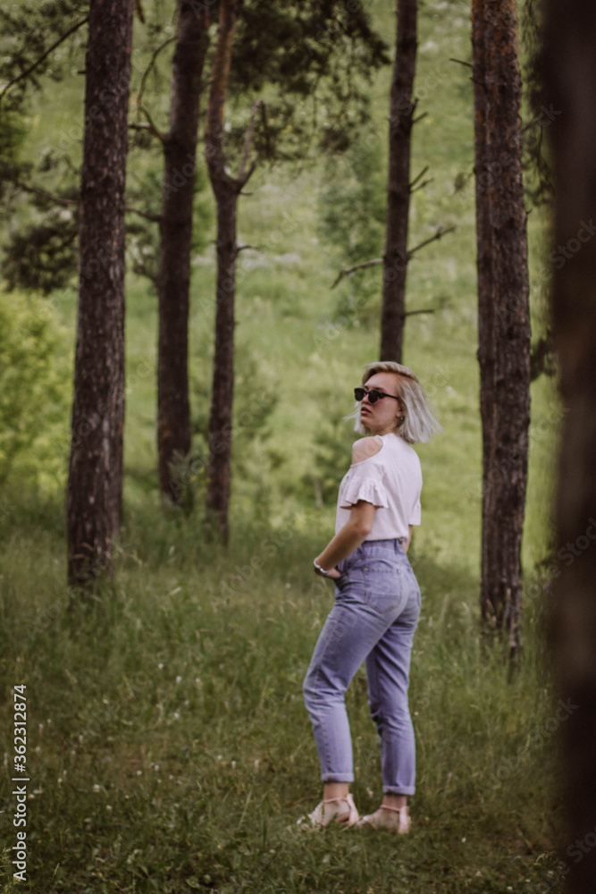young woman walks in the forest, blonde with glasses young woman walks in the forest, blonde with glasses