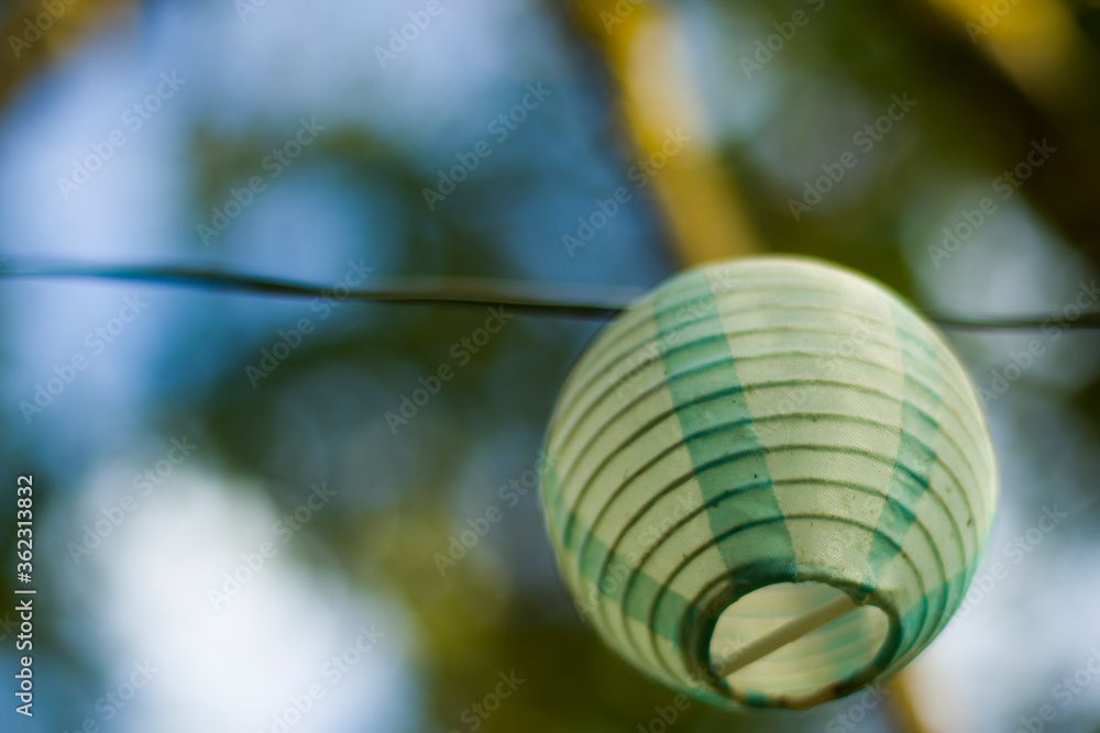 Fototapeta premium Lantern in the yard on the tree bokeh background, night and warm light, hanging lanterns.