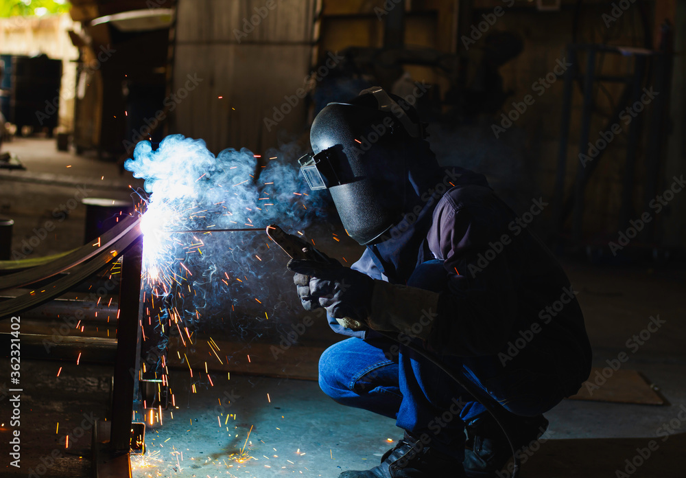 Metal workers use manual labor. Skilled welder. Factory workers making OT. Welder is welding the steel in the factory. welder Industrial automotive part in factory. Metal workers use manual labor. Skilled welder. Factory workers making OT. Welder is welding the steel in the factory. welder Industrial automotive part in factory.