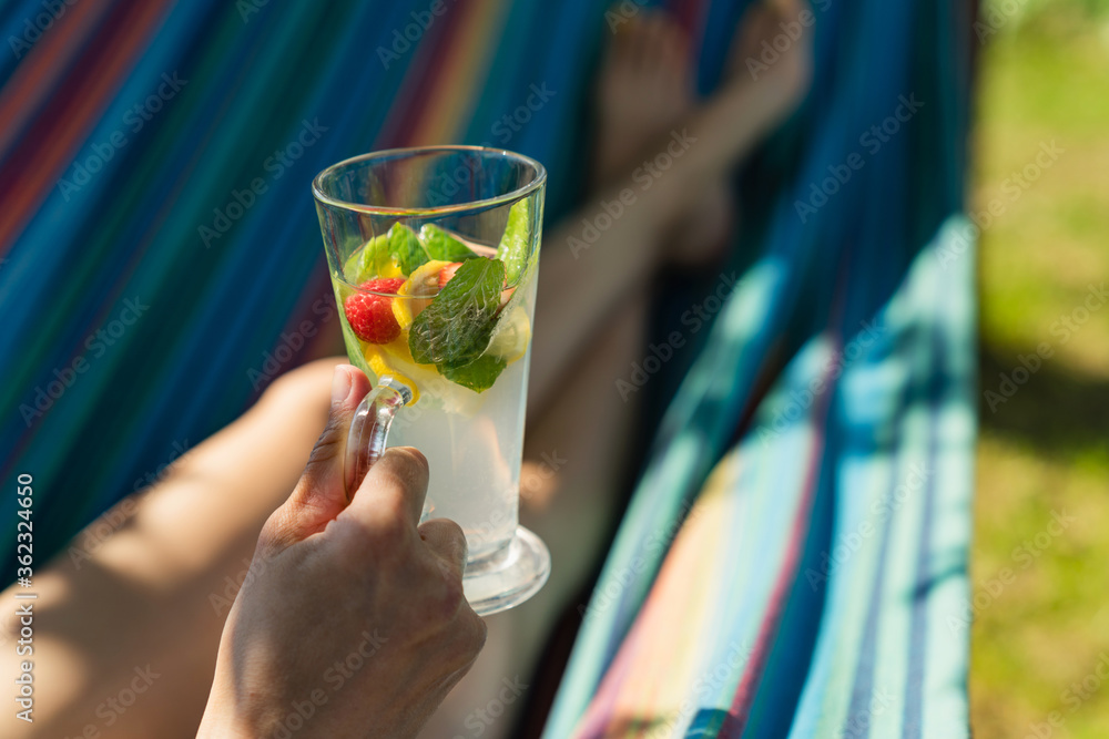 Fototapeta premium Woman with cocktail relaxed in hammock