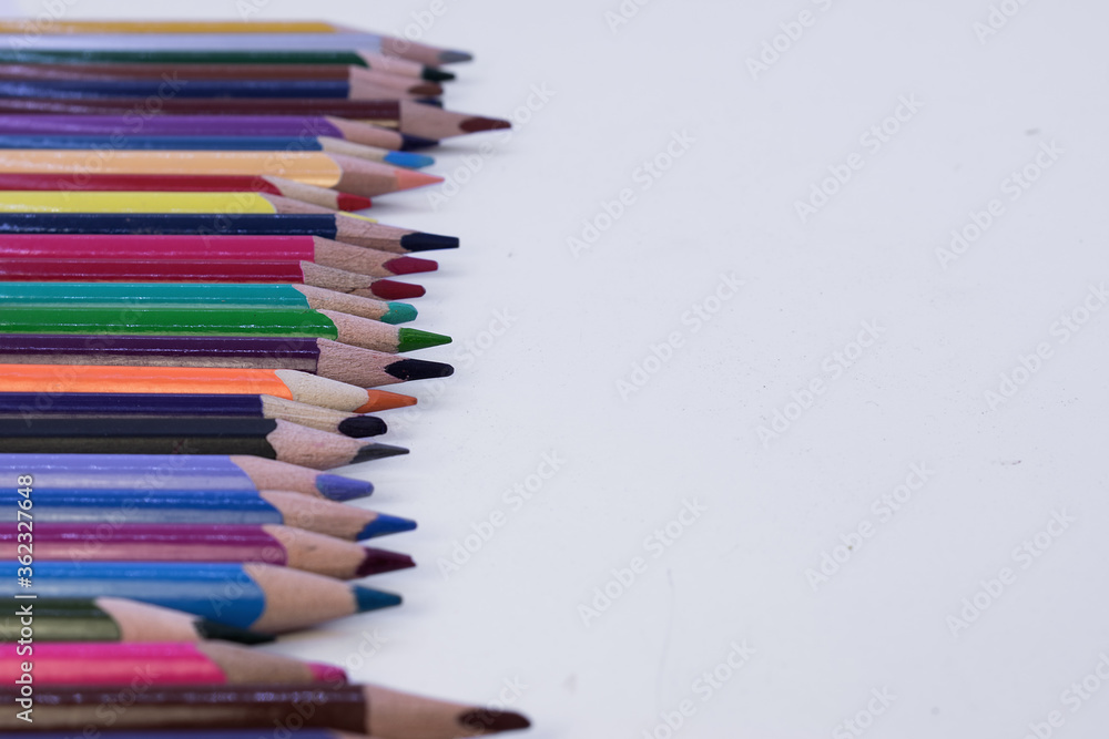 colored pencils laid out in a row on the left on a white background colored pencils laid out in a row on the left on a white background