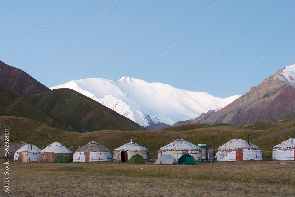 Morning Sunlight Landscape of Lenin Peak (7134m) at Tourist Yurt camp of Tulpar Kol Lake in Alay Valley, Osh, Kyrgyzstan.  Pamir mountains in Kyrgyzstan.