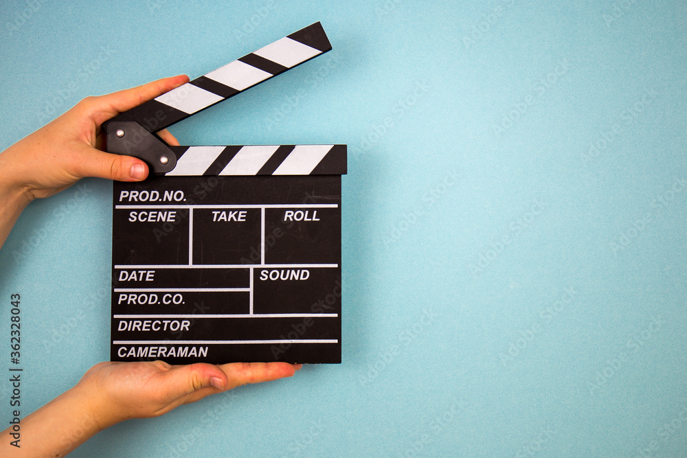 Obraz premium Klakier filmu na niebieskim tle, koncepcja kina