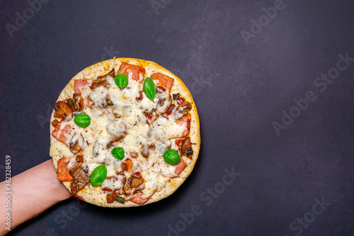 pizza with mushrooms, Basil and cheese on a dark background. copy space. The view from the top. flat lay.