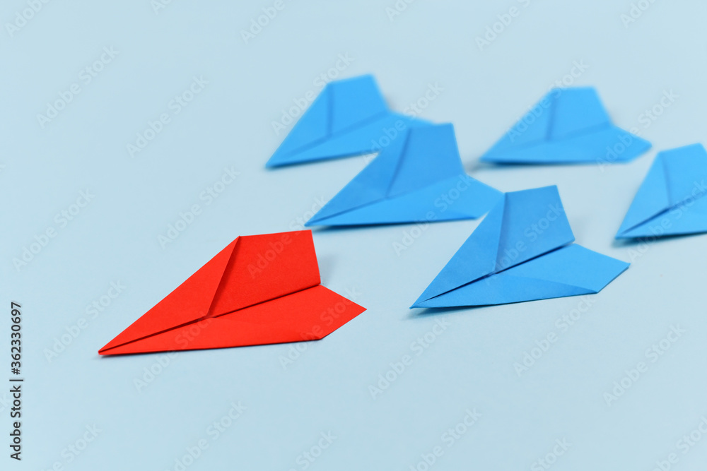 Red paper airplane leading blue airplanes. Concept for discovery and ...