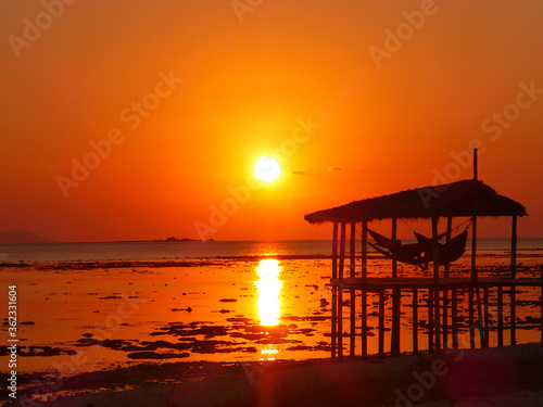Silhouette of a cabana at sunset from Kanawa Island, Indonesia © Samantha