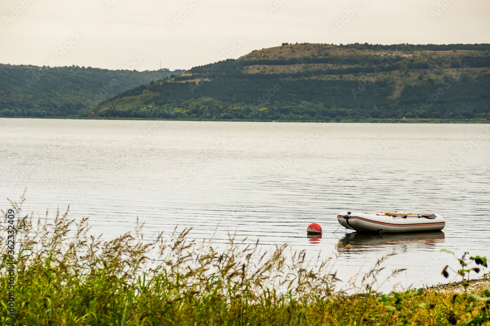 a morning landscape of Bakota bay (Dnistrovske reservoir) with empty fishing boat, Dnister river, Podilski tovtry National park, Khmelnitskiy region of Western Ukraine