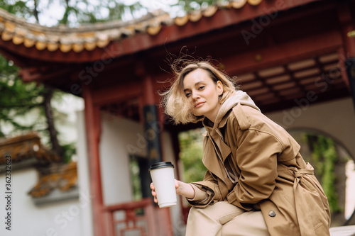 girl with a mug of coffee near Chinatown park bokeh background