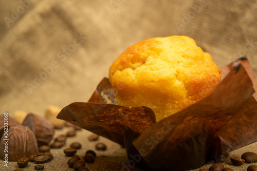 Slika na platnu Fresh cupcake, coffee beans and chocolate on a homespun fabric with a rough texture