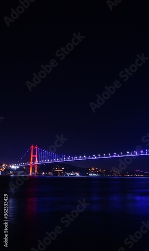 Bosphorus bridge at night in Istanbul, navy blue sky and sea