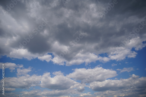 Blue sky with gray dark clouds on sunny day. Nature background.