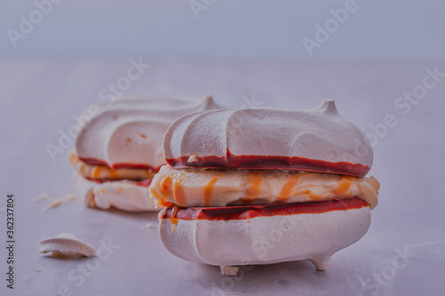 Toffee cream filled meringues on a white surface with white background. photo