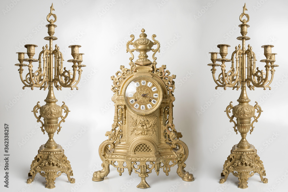 Vintage gold watch with candelabra on white background, bronze clock and candelabra, gold candlesticks and clock, antique clock and candlesticks, vintage clock with chandeliers on a white background	
