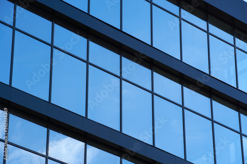 facade of a modern building on a bright Sunny day  blue sky and clouds reflecting in a glass  beautiful exterior of the new building