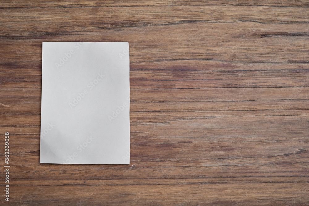 White paper pad on wood desk background with copy space. Top down White paper pad on wood desk background with copy space. Top down