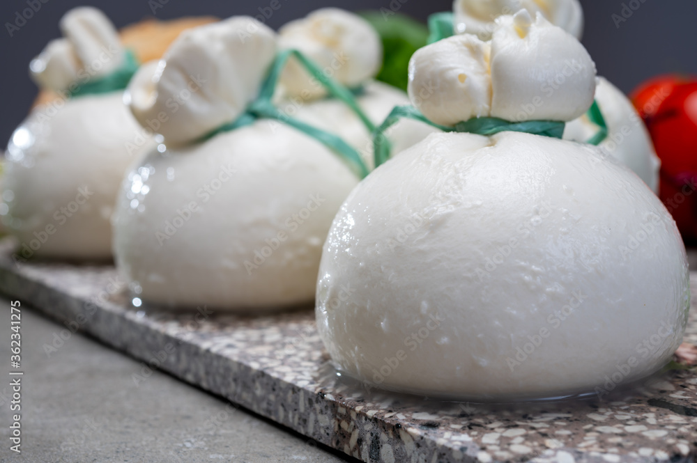 Cheese collection, fresh soft Italian cheese from Puglia, white balls of burrata or burratina cheese made from mozzarella and cream filling Cheese collection, fresh soft Italian cheese from Puglia, white balls of burrata or burratina cheese made from mozzarella and cream filling