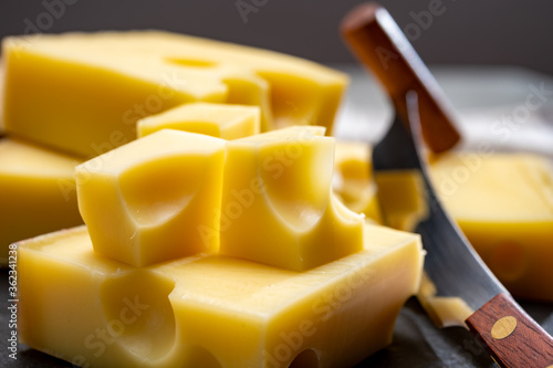 Block of Swiss medium-hard yellow cheese emmental or emmentaler with round holes and cheese knife photo