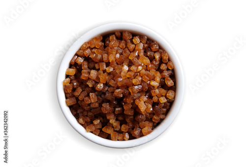 Bowl of Crystal Sugar isolated on white background, top view. Brown cane sugar