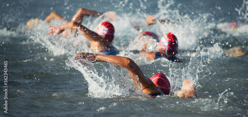 Photo Competitors swimming out into open water at the beginning of triathlon