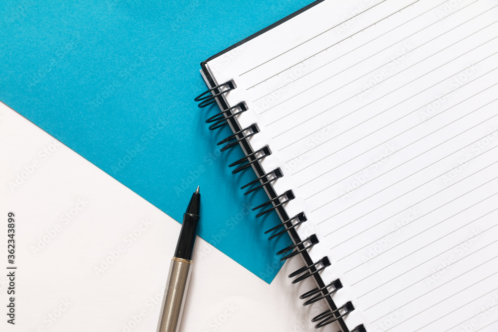 Flat lay of blank Notebook and pen on split color white and blue background. Flat lay of blank Notebook and pen on split color white and blue background.