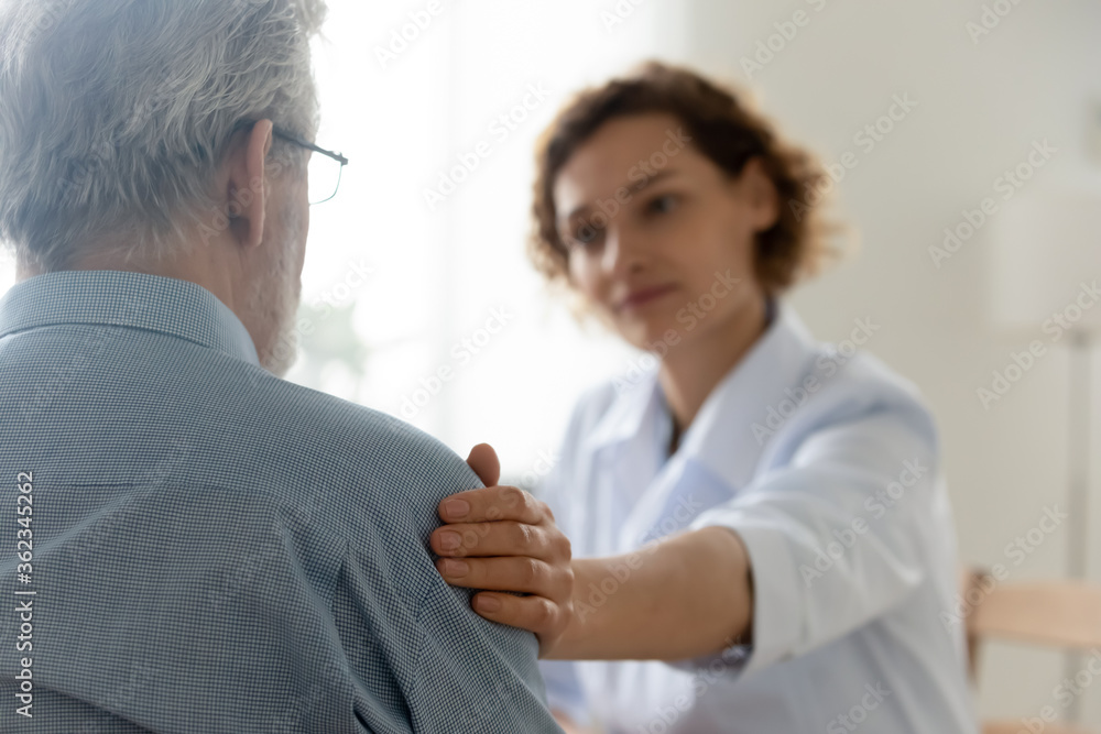Close up of caring young Caucasian female nurse or caregiver touch support senior male patient, attentive woman doctor or GP feel supportive comfort upset mature man client, elderly healthcare concept Close up of caring young Caucasian female nurse or caregiver touch support senior male patient, attentive woman doctor or GP feel supportive comfort upset mature man client, elderly healthcare concept