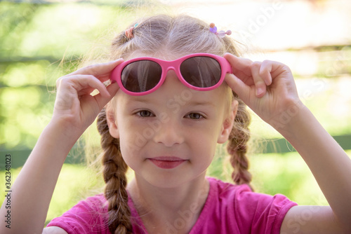 little Caucasian girl holding sunglasses