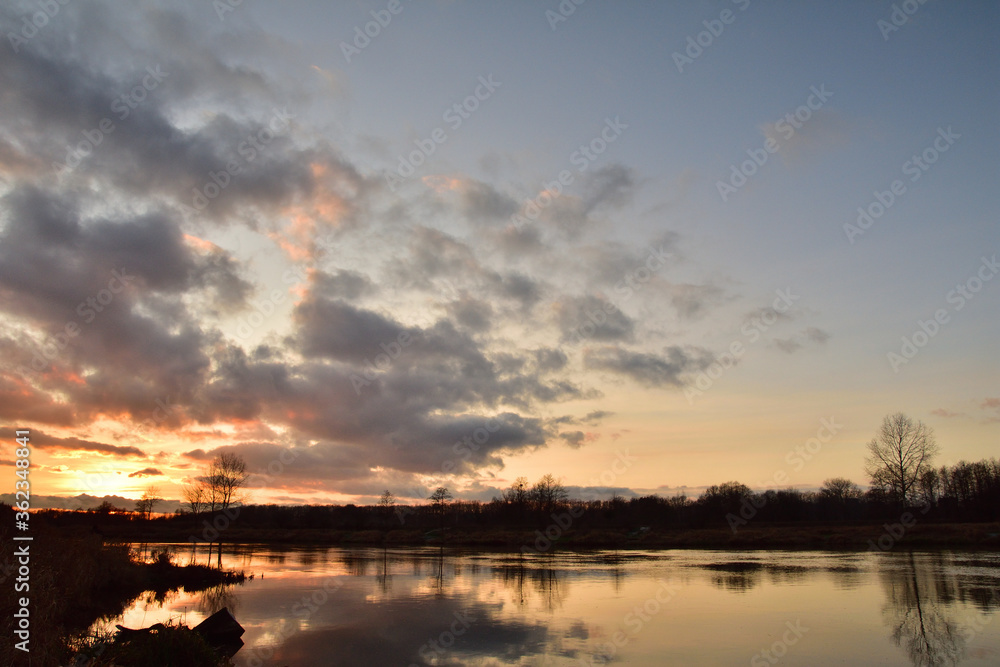 Obraz premium Sunset over a wide river on a cool spring day. Fish eye lens.