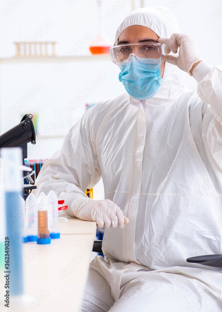 Naklejka premium Young chemist student working in lab on chemicals