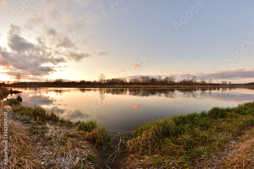 Sunset over a wide river on a cool spring day. Fish eye lens.