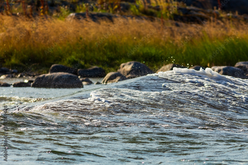 Fototapeta premium Water flowing over rocks by the shore