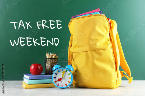 Φωτογραφία Backpack with school stationery and text TAX FREE WEEKEND written on chalkboard