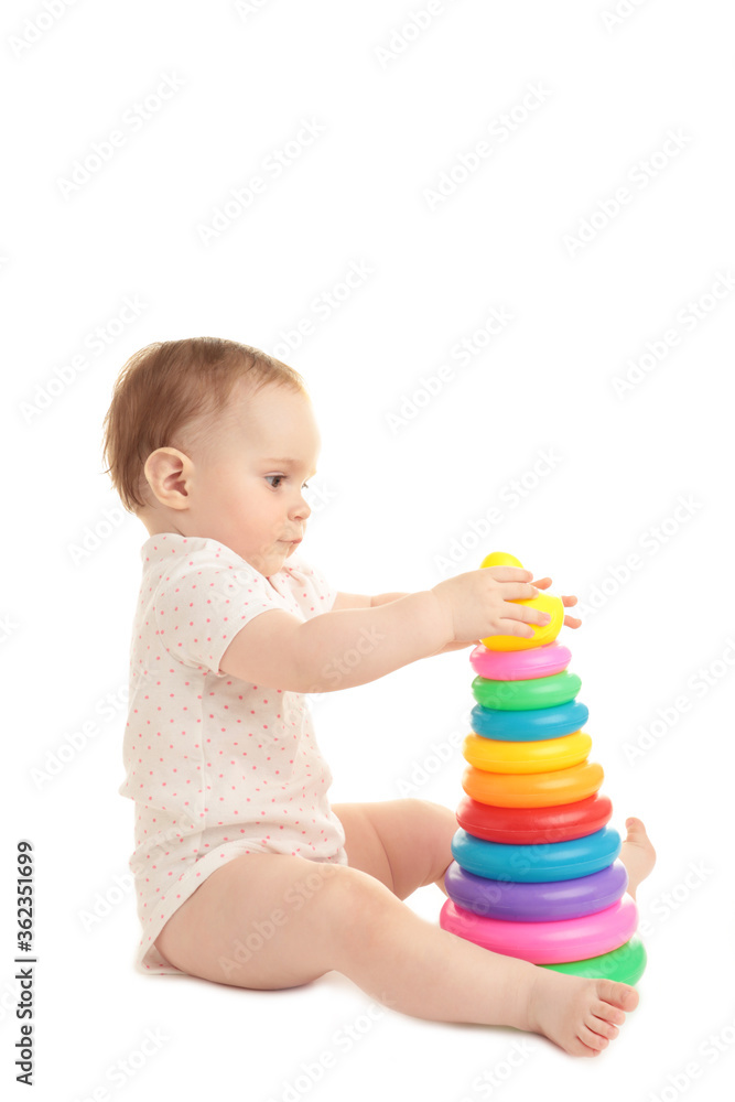 Cute baby playing with colorful rainbow pyramid isolated on a white background. Child with educational toy. Cute baby playing with colorful rainbow pyramid isolated on a white background. Child with educational toy.