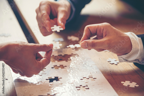 Implement improve puzzel solve connections together with synergy strategy team building organizing connection by trust communication. Hands of stakeholders business trust team holding jigsaw puzzle photo