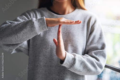 Closeup image of a woman making time out hand sign photo