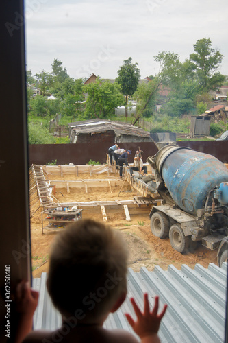 A child watches a construction site from a window
