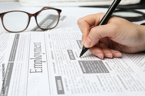Woman marking advertisement in newspaper, closeup. Job search concept
