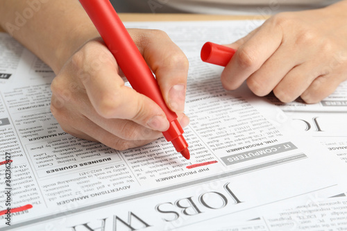 Woman marking advertisement in newspaper, closeup. Job search concept