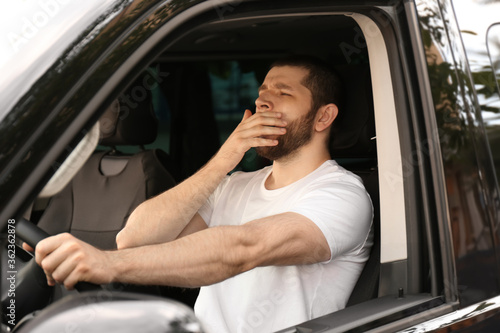 Εκτύπωση καμβά Tired man yawning while driving his modern car