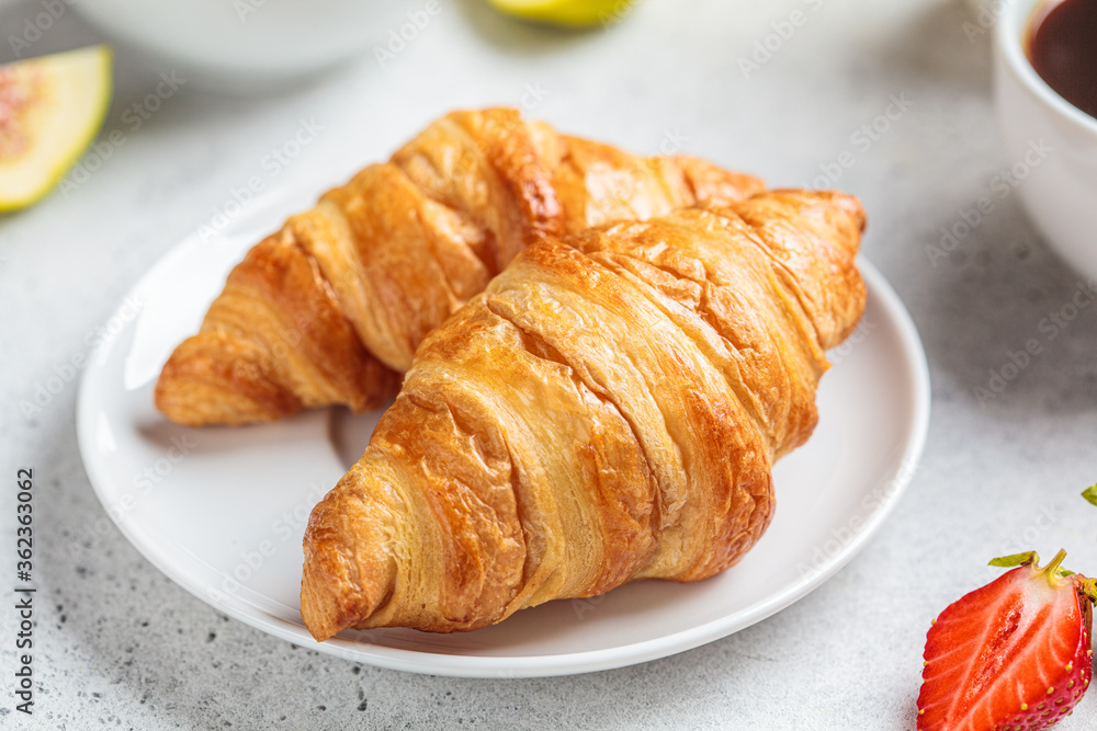 Breakfast croissants with coffee, juice and fruit.